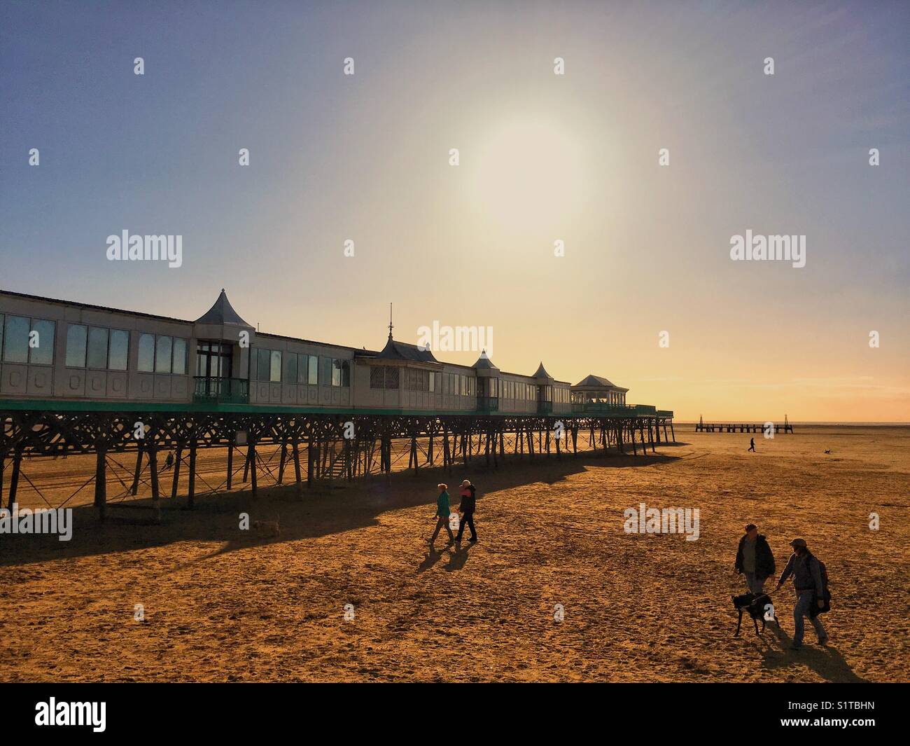 People walking on St Annes beach at low tide Stock Photo