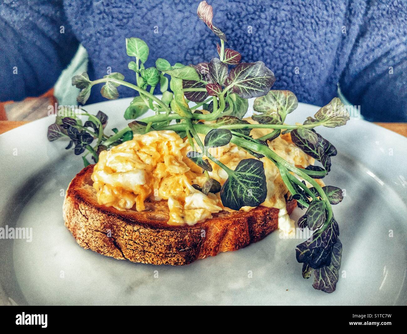 Woman having breakfast, scrambled eggs on toast - Smartphone Captured Stock Image