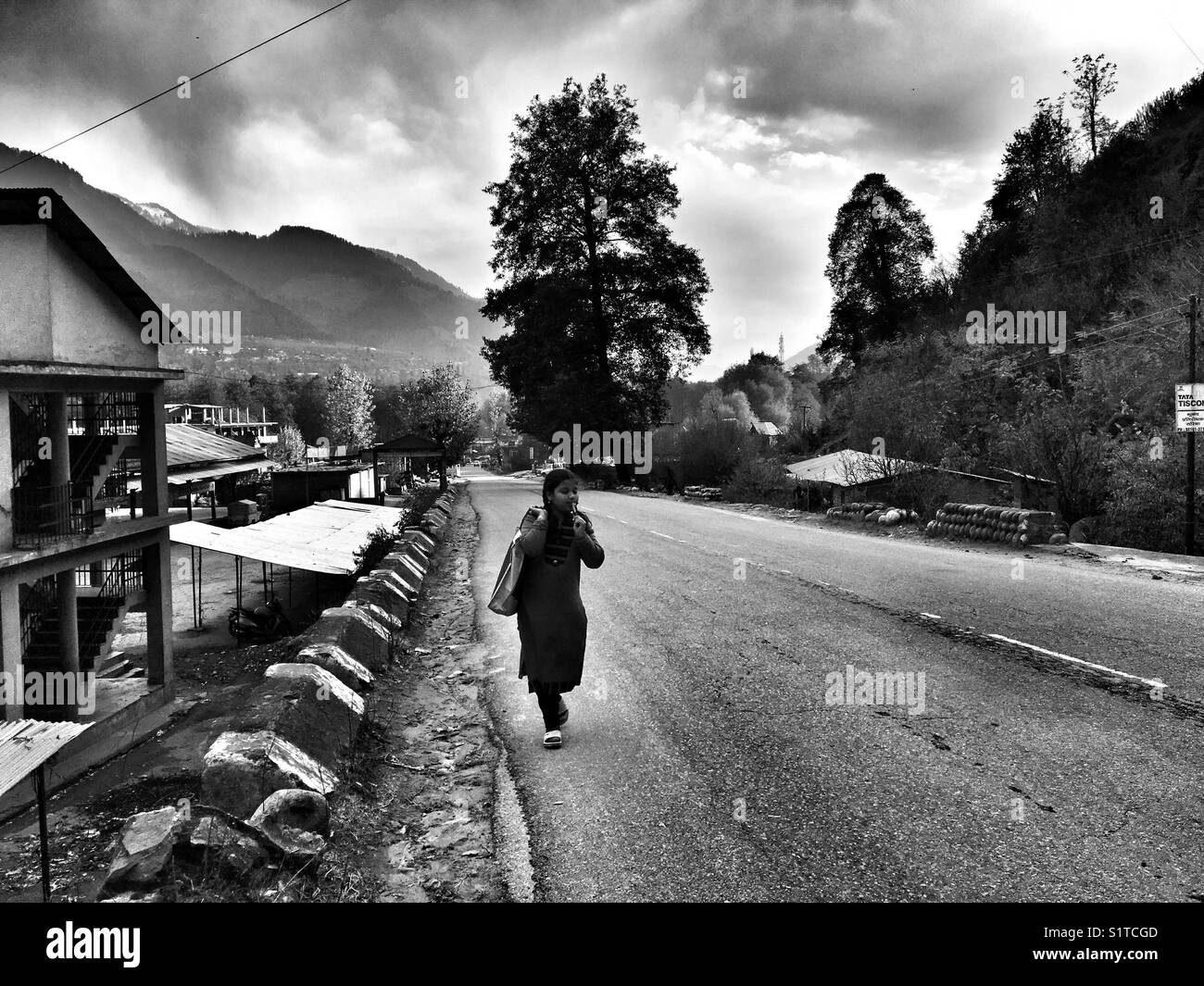 A girl walks on Kullu Manali highway - Smartphone Captured Stock Image