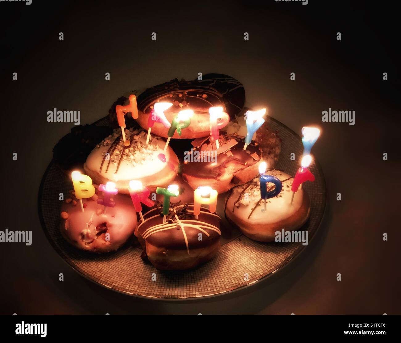 Candles spelling Happy Birthday on donuts - Smartphone Captured Stock Image