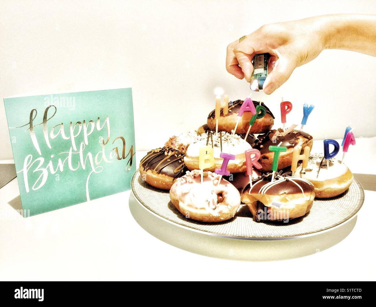 A hand lighting candles on birthday cakes Stock Photo Alamy