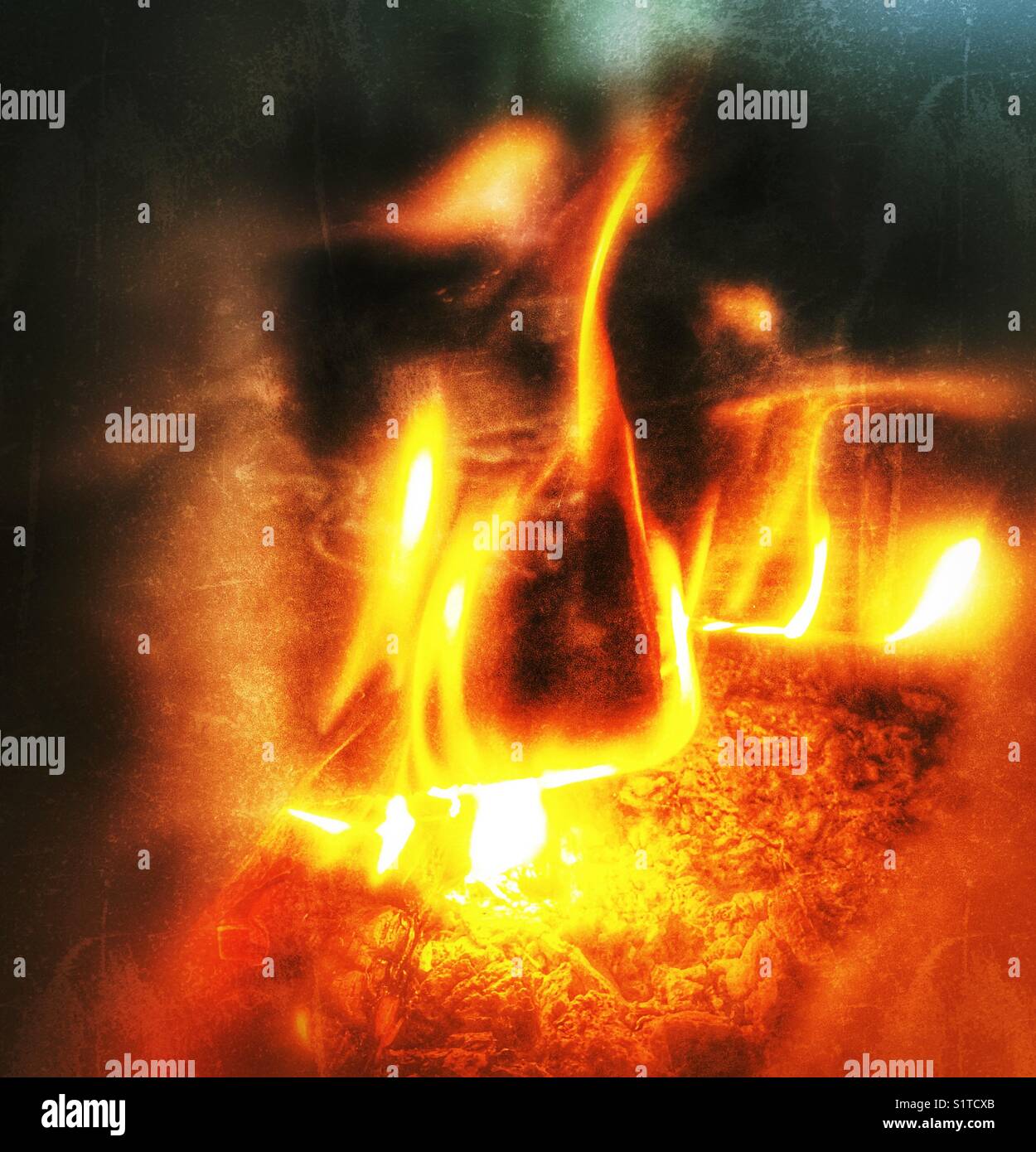 Close up view of flames seen through a viewing window in a wood stove - Smartphone Captured Stock Image