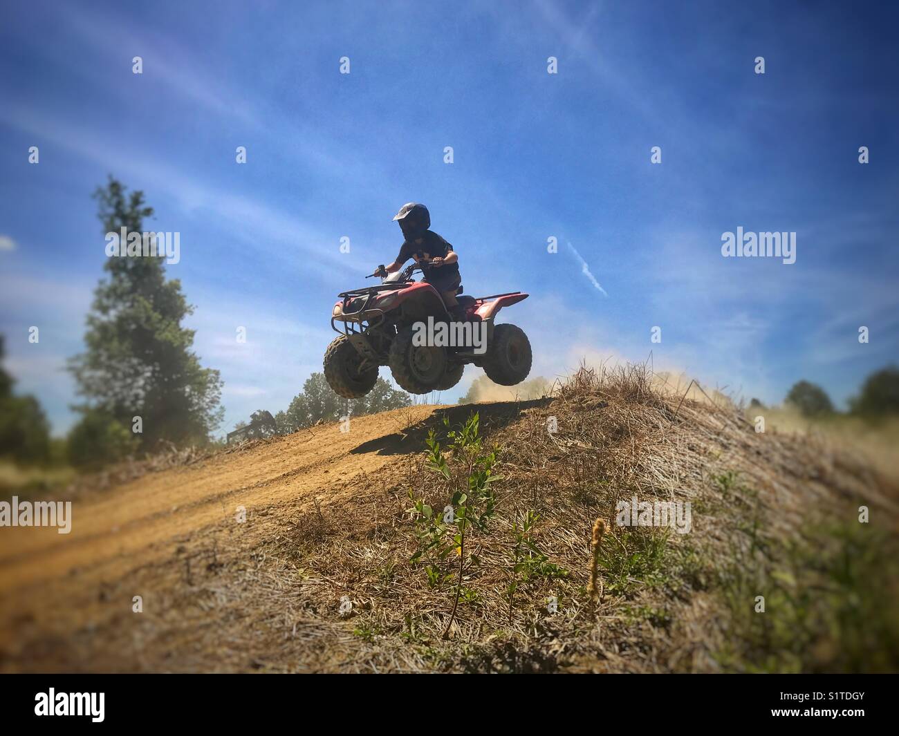 Boy jumping a 4-wheeler ATV. Stock Photo