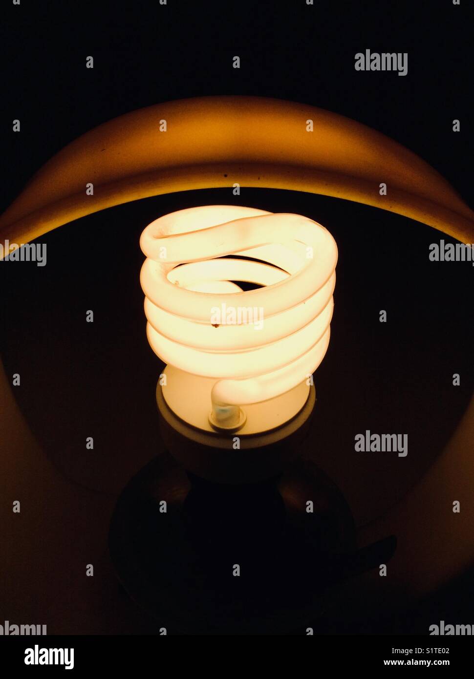 Compact fluorescent lamp (CFL), 20 Watt spiral bulb switched on Stock