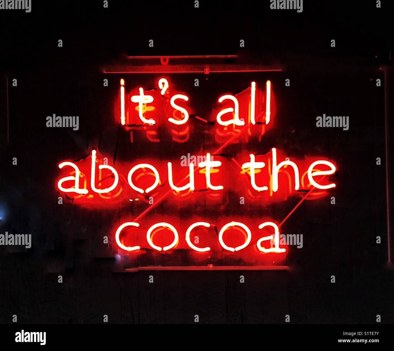 A fluorescent neon sign saying it’s all about the cocoa Stock Photo