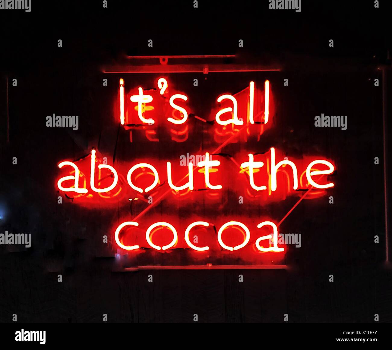 A fluorescent neon sign saying it’s all about the cocoa - Smartphone Captured Stock Image