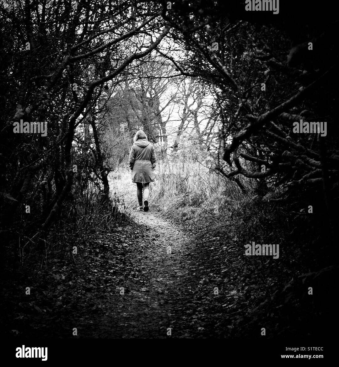 Female walking along a wooded path Stock Photo - Alamy