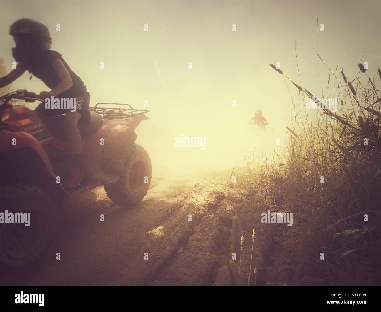 ATV riding on a dusty track. Stock Photo