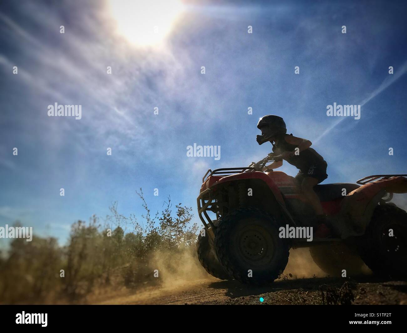 Boy wearing helmet riding ATV. Stock Photo