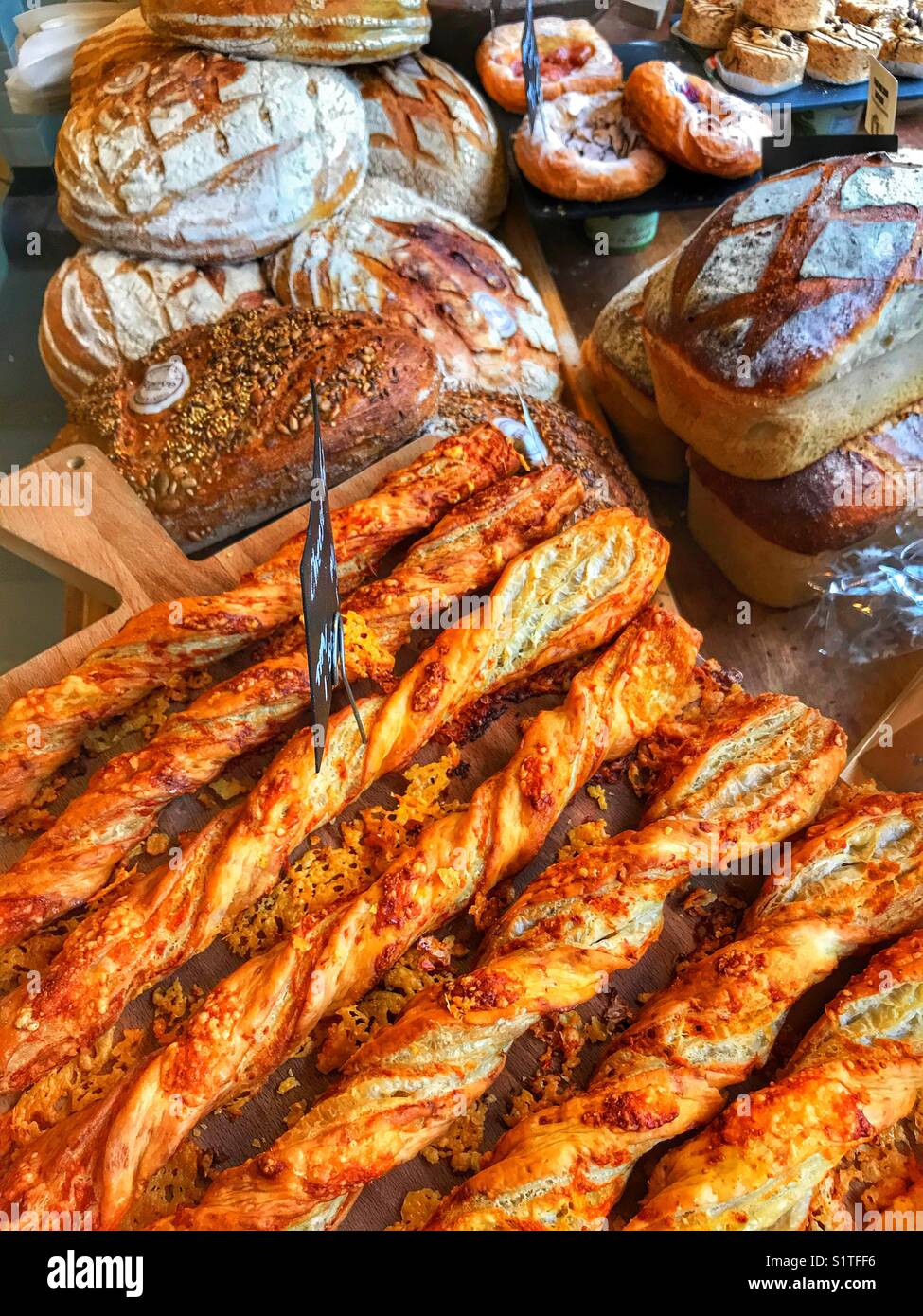 Cheeses straws and a different types of bread loaves and pastries on ...