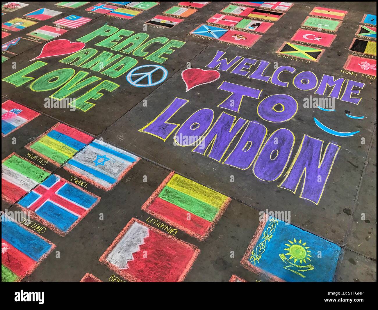 'Peace And Love'....' Welcome To London'...   Street Art on the Pavement. Chalk Artwork showing how London embraces people from all around the world. Photo © COLIN HOSKINS. - Smartphone Captured Stock Image