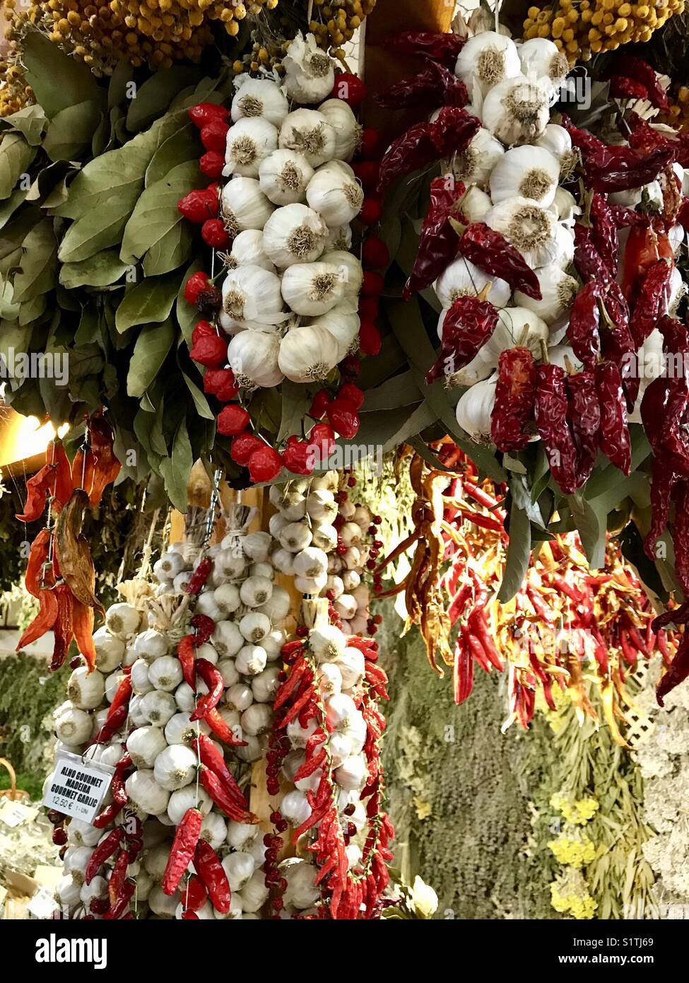 Garlic, chilliest and peppers on display in the farmer’s market in Funchal, Madeira - Smartphone Captured Stock Image