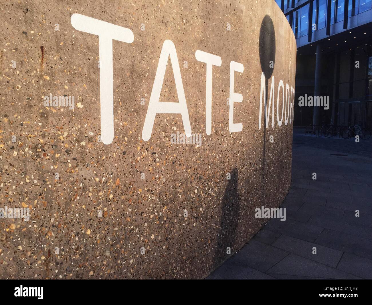Shadows are seen on a Tate Modern sign on a wall outside Tate Modern in Bankside in London, England on December 1 2017 Stock Photo