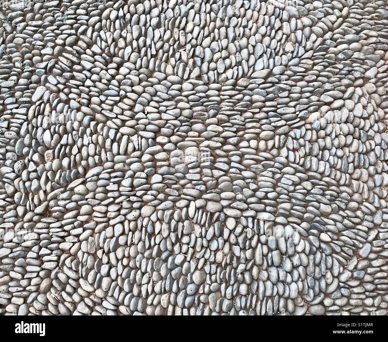 Pattern formed by small stones on a sidewalk - Smartphone Captured Stock Image