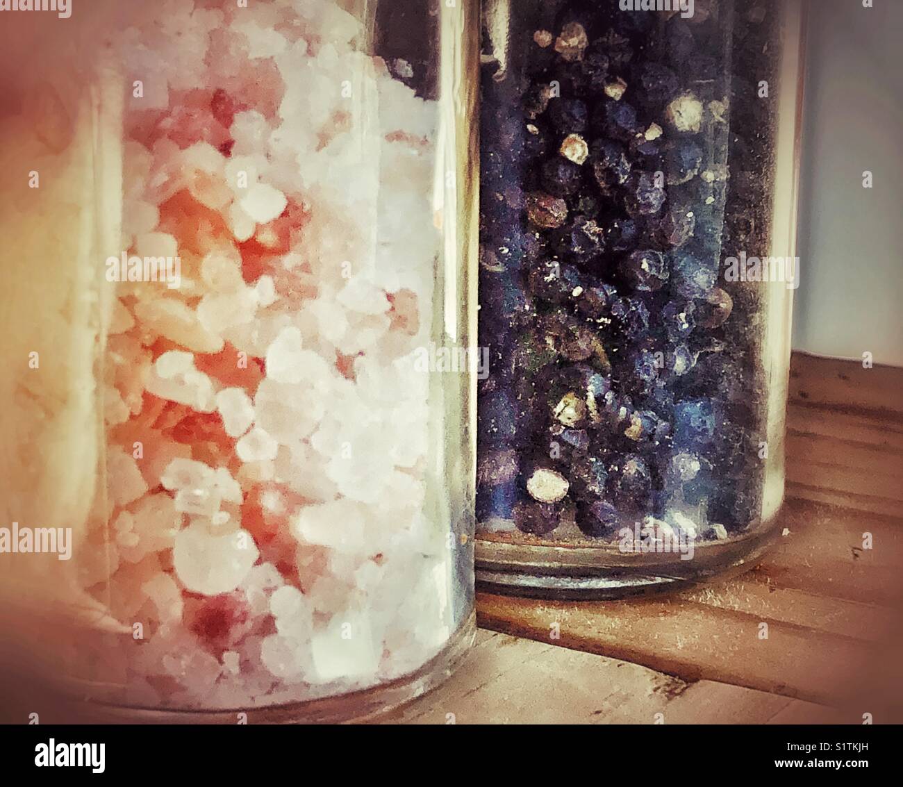 Closeup of Himalayan pink rock salt and black peppercorns in glass grinders - Smartphone Captured Stock Image