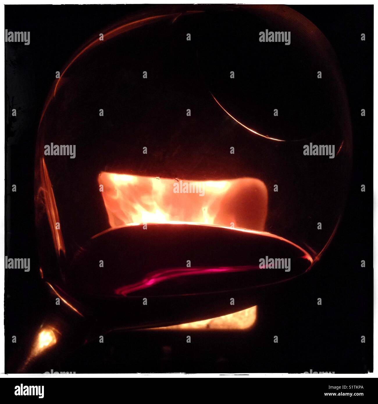 Drinking red wine by the fire. - Smartphone Captured Stock Image