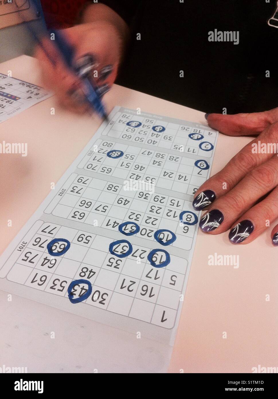Lady with painted nails, playing bingo Stock Photo Alamy