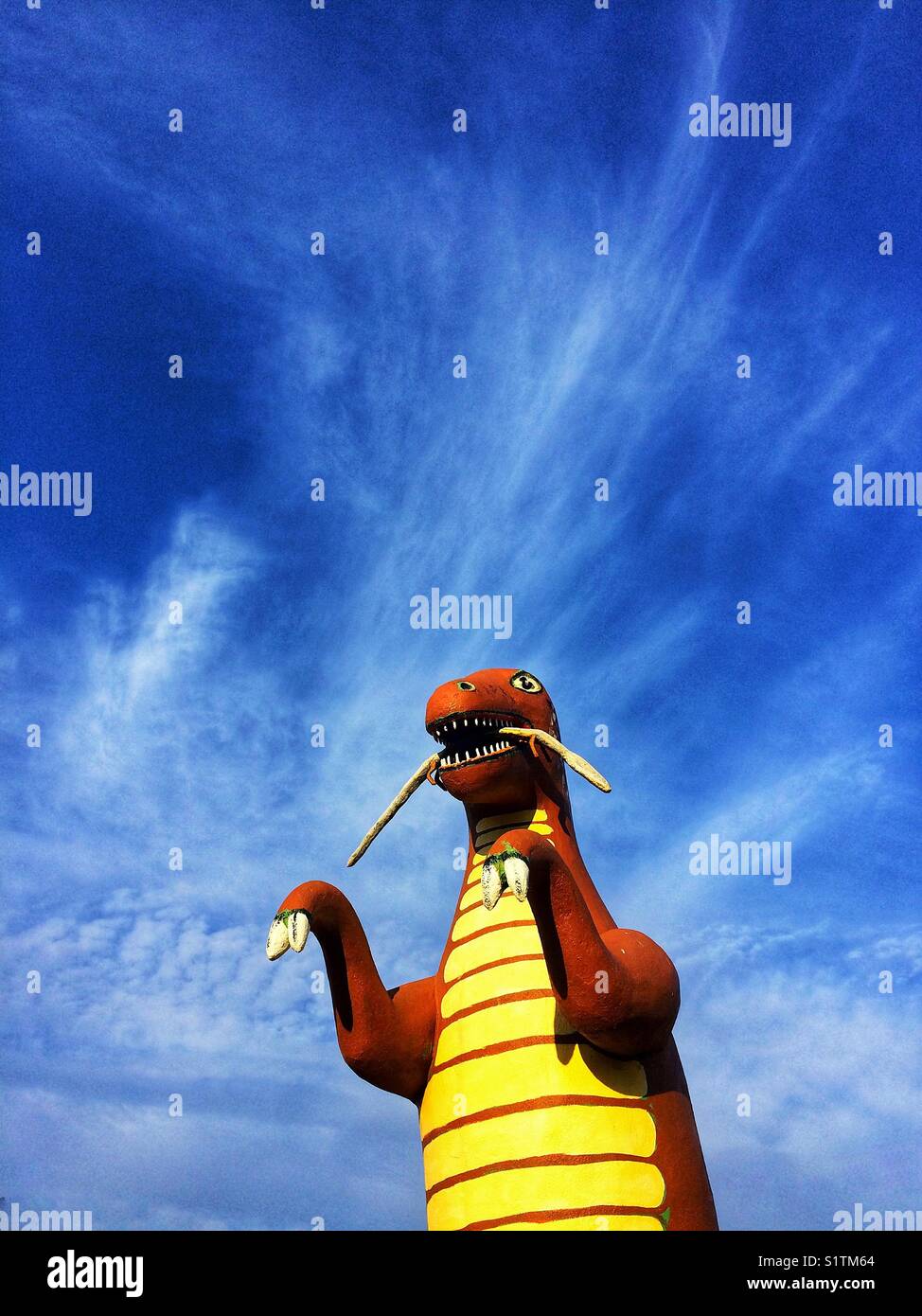 Dinosaur toy on blue sky background at Holbrook, Arizona,USA - Smartphone Captured Stock Image