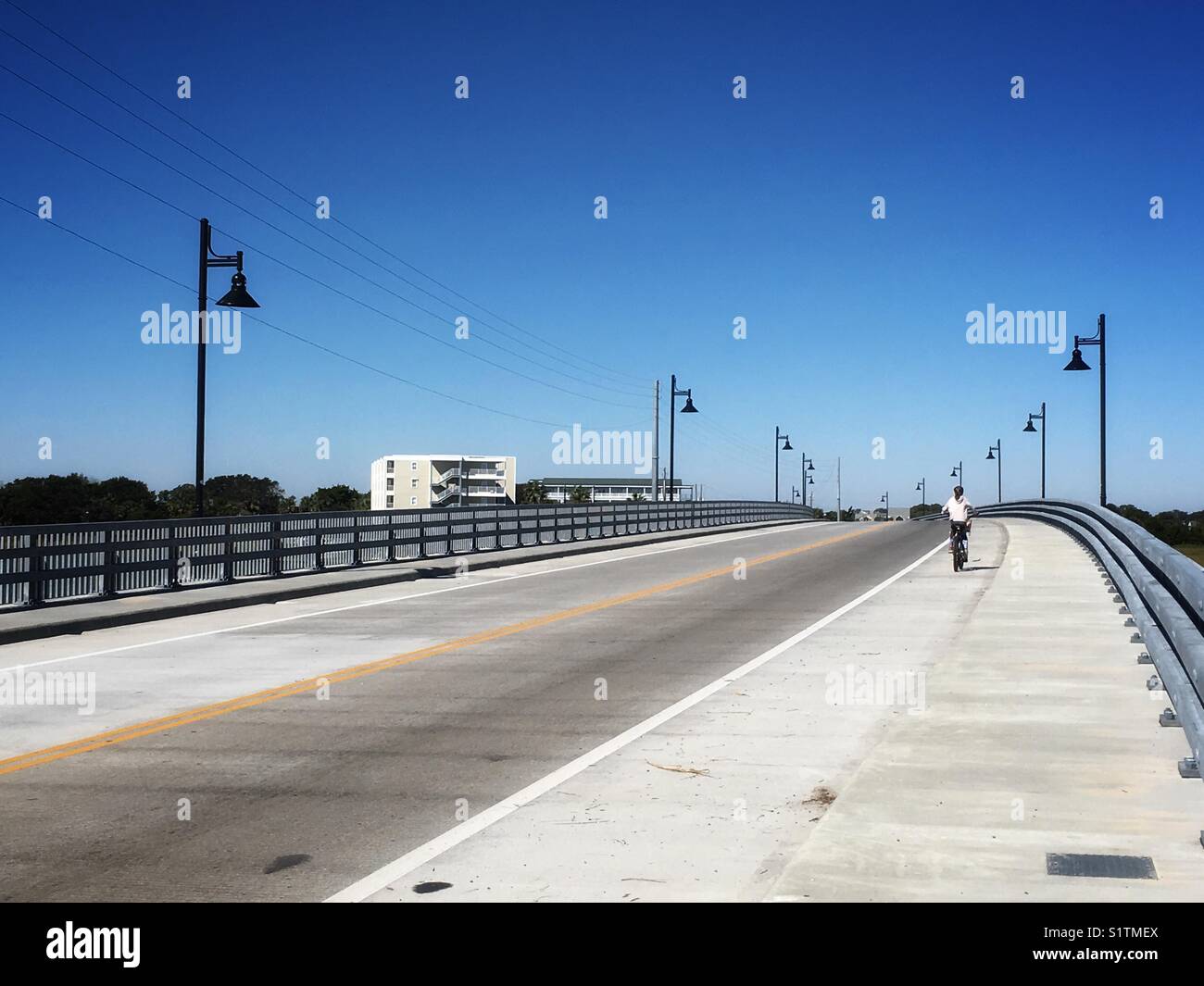A person on bicycle at the bridge with lanterns in Charleston, SC, USA - Smartphone Captured Stock Image