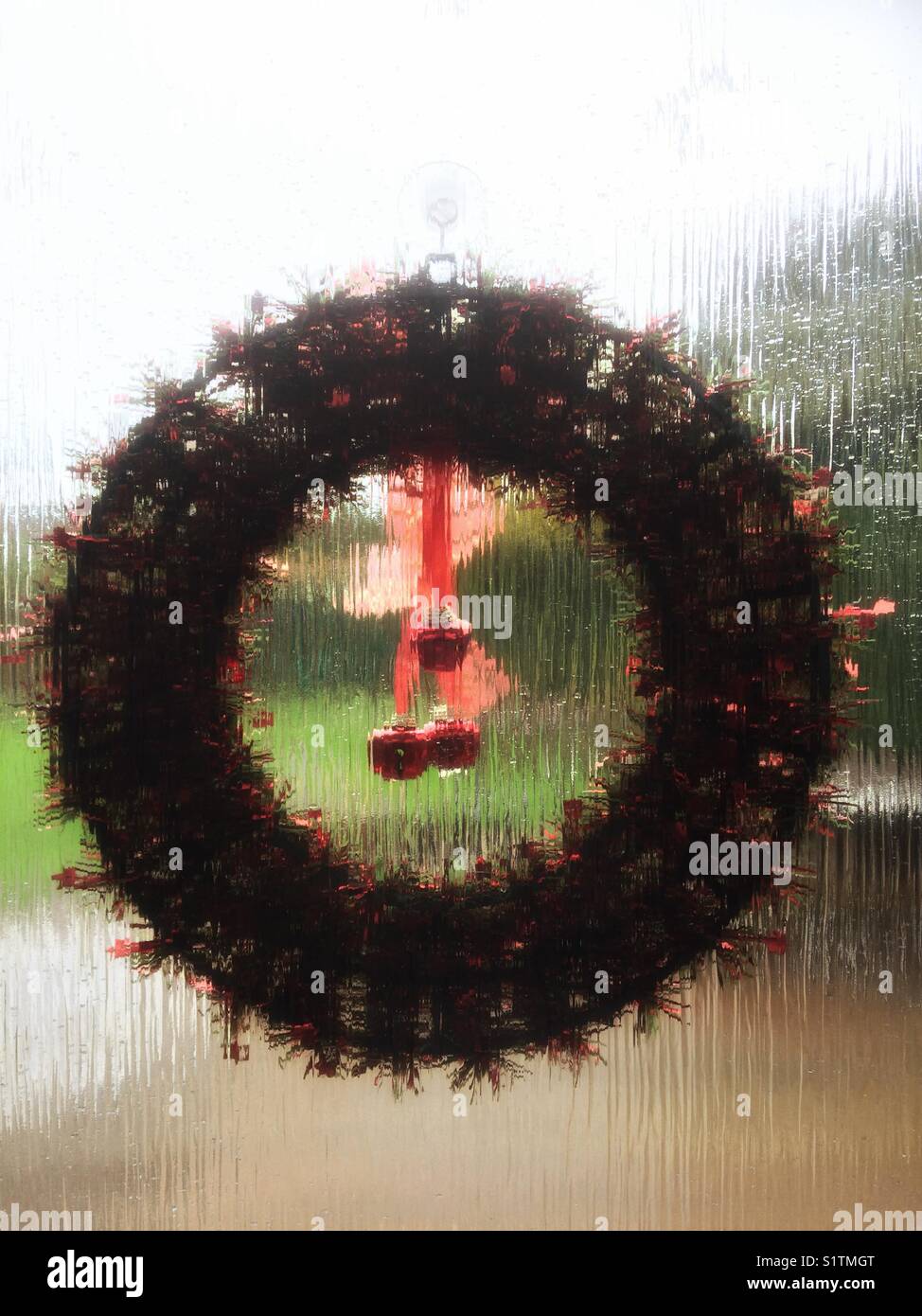 Looking Through A Christmas Wreath Hanging On A Glass Door At The