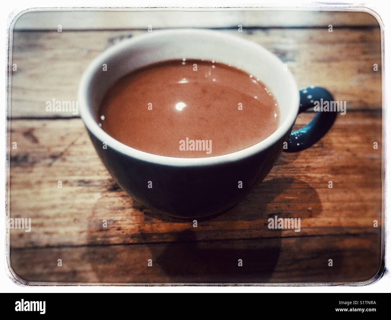 A cup of coffee on a natural wood table. Stock Photo