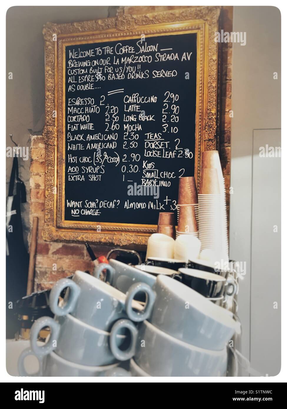 Coffee shop menu board and a stack of blue cups. Stock Photo