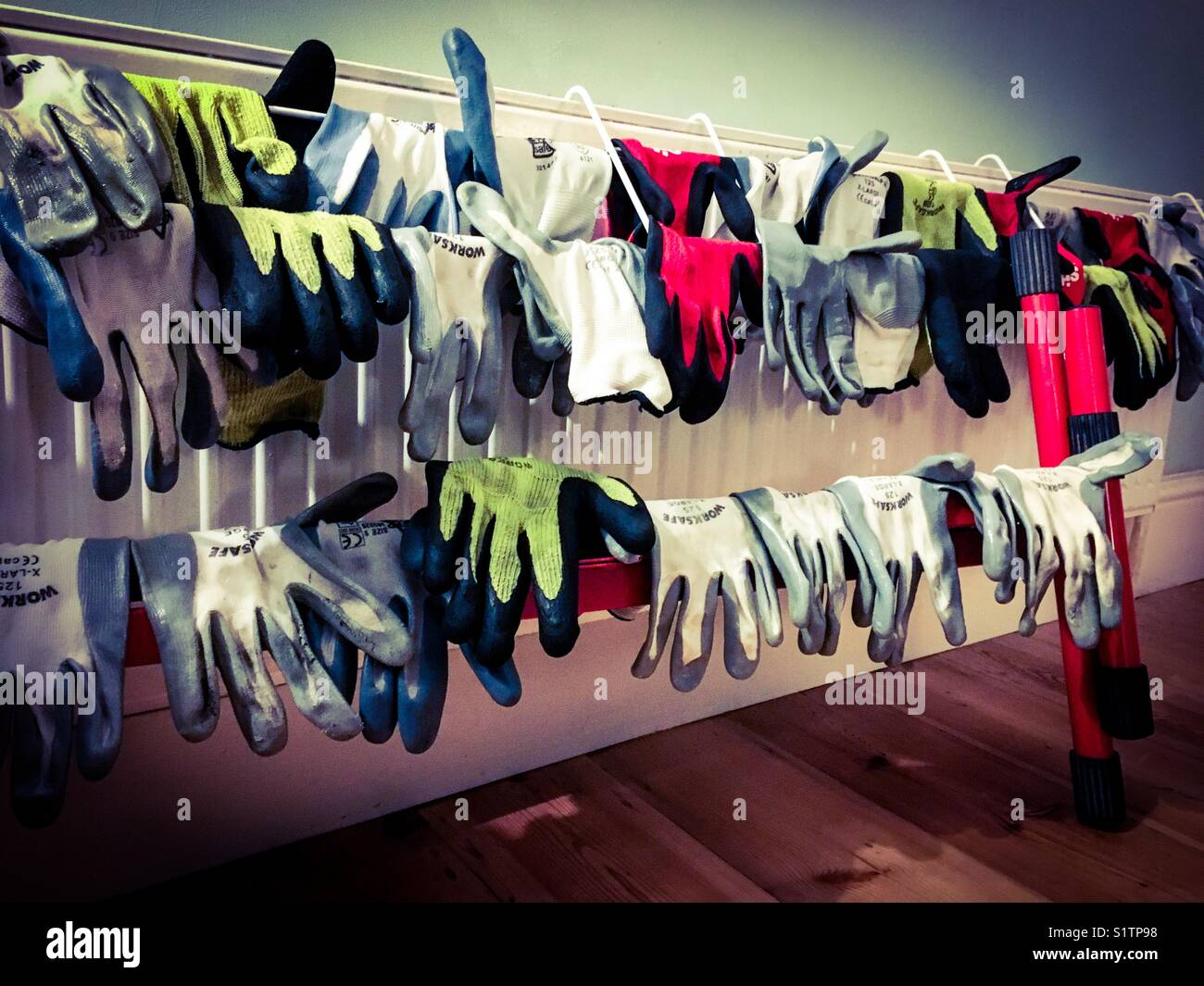 Pairs of builder’s gloves hanging to dry. - Smartphone Captured Stock Image