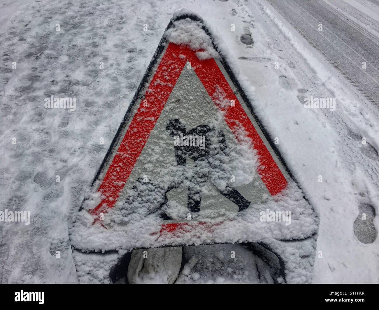 A men at work sign covered in snow - Smartphone Captured Stock Image