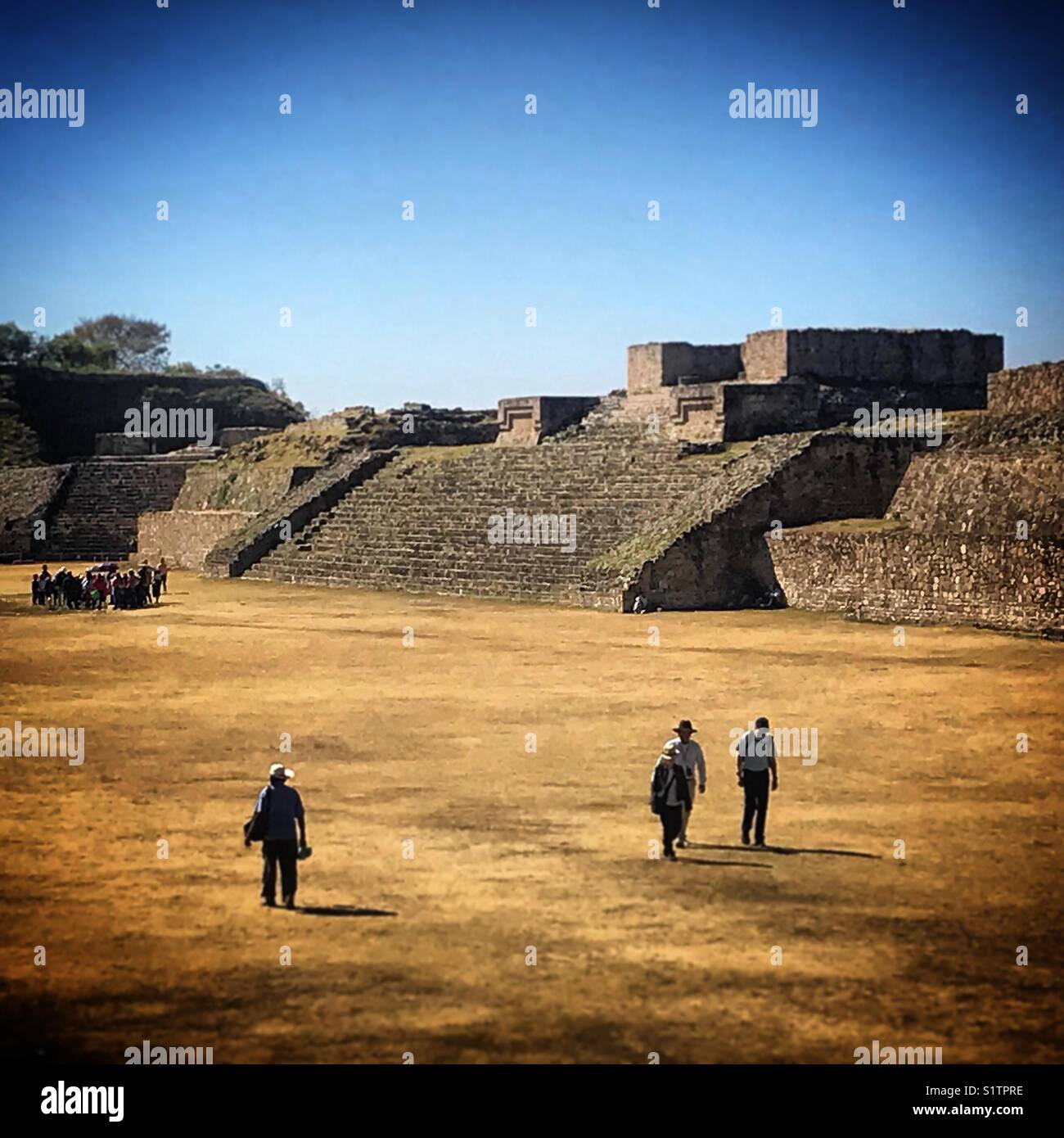 People walk in the ancient city of Monte Alban in Oaxaca, Mexico Stock Photo