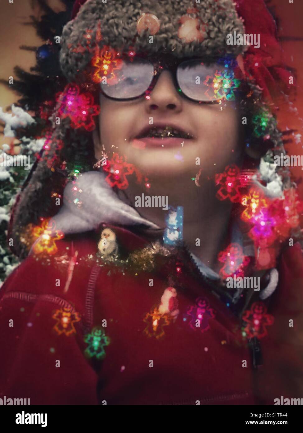 Dreams of sugarplums! Double exposure of child looking at snow falling and Christmas lights Stock Photo