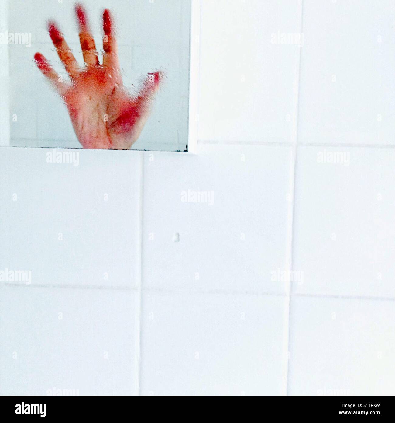 Hand in bathroom mirror Stock Photo