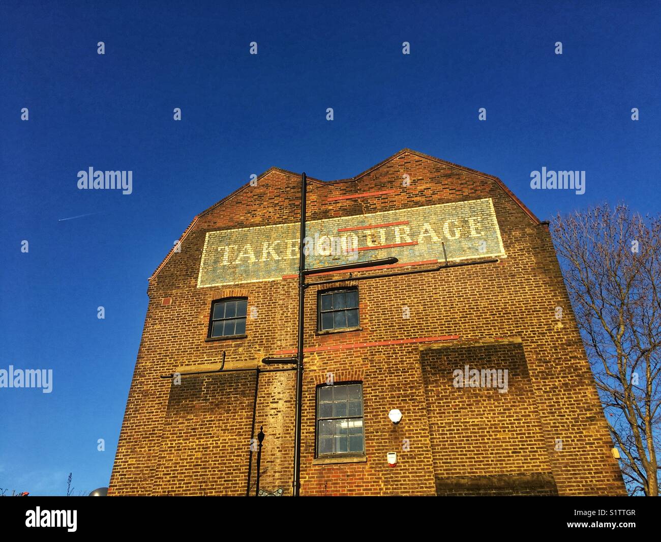 Take Courage Advert on What used to be The Courage & Co. Ltd Brewery in Southwark, London Stock Photo
