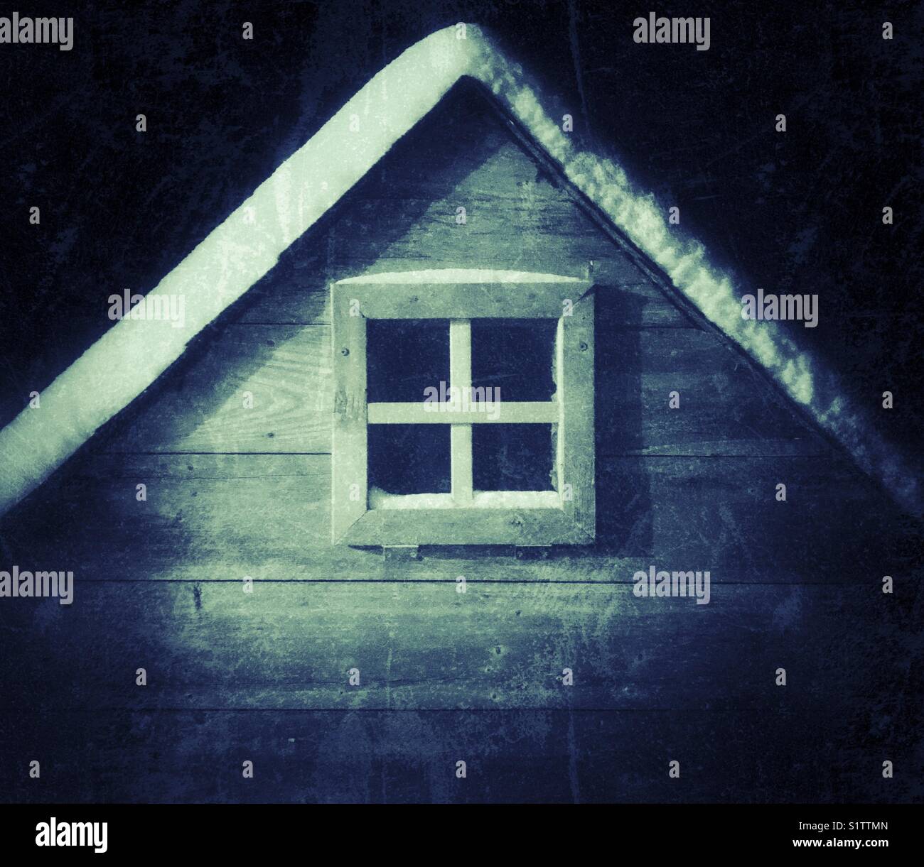 Chicken coop window at night with snow on roof above and creepy
