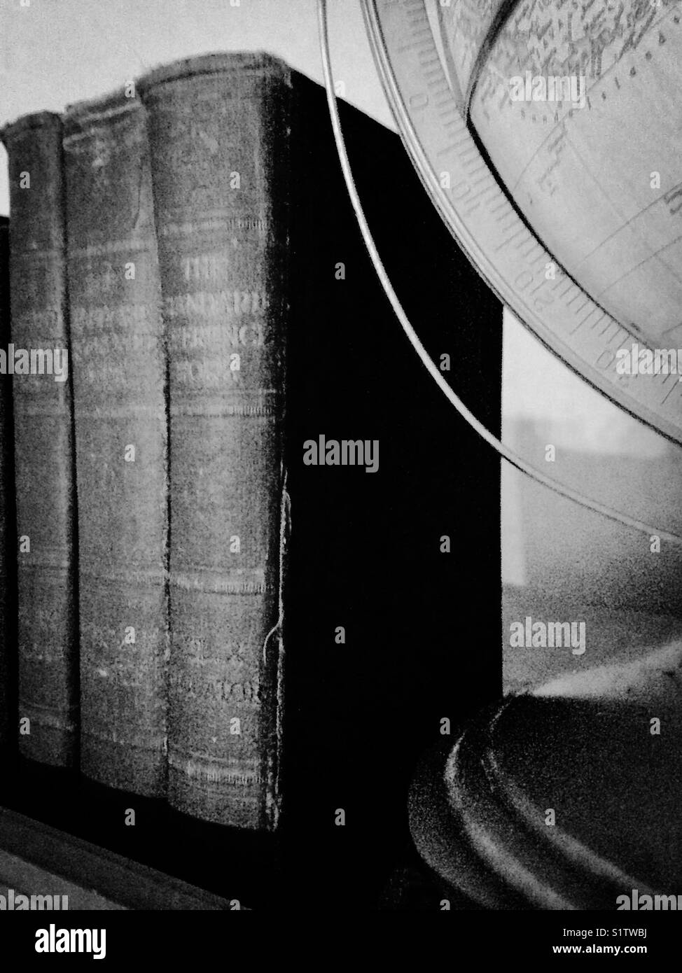 Black and white photo of antique books and globe - Smartphone Captured Stock Image
