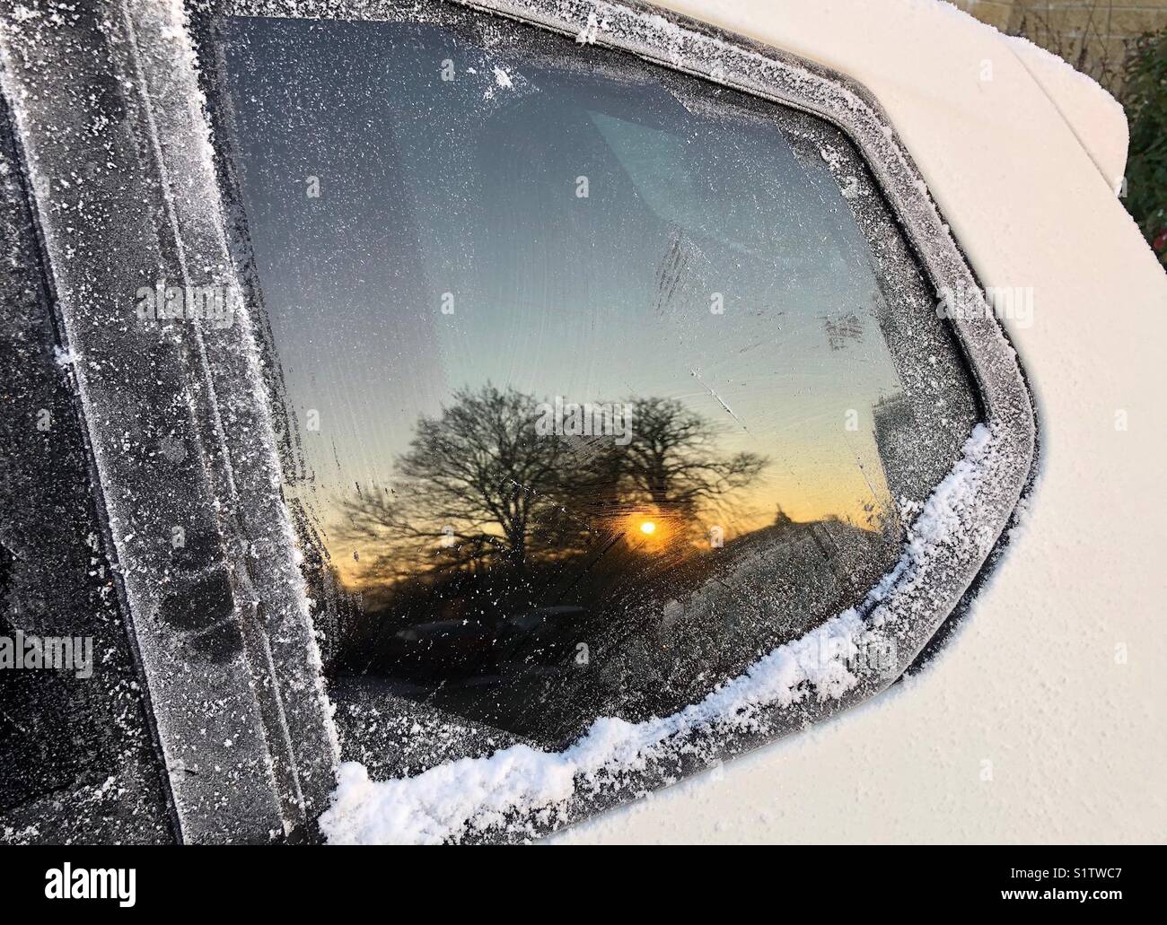 Reflection of sunrise in a car window scraped free of frost - Smartphone Captured Stock Image