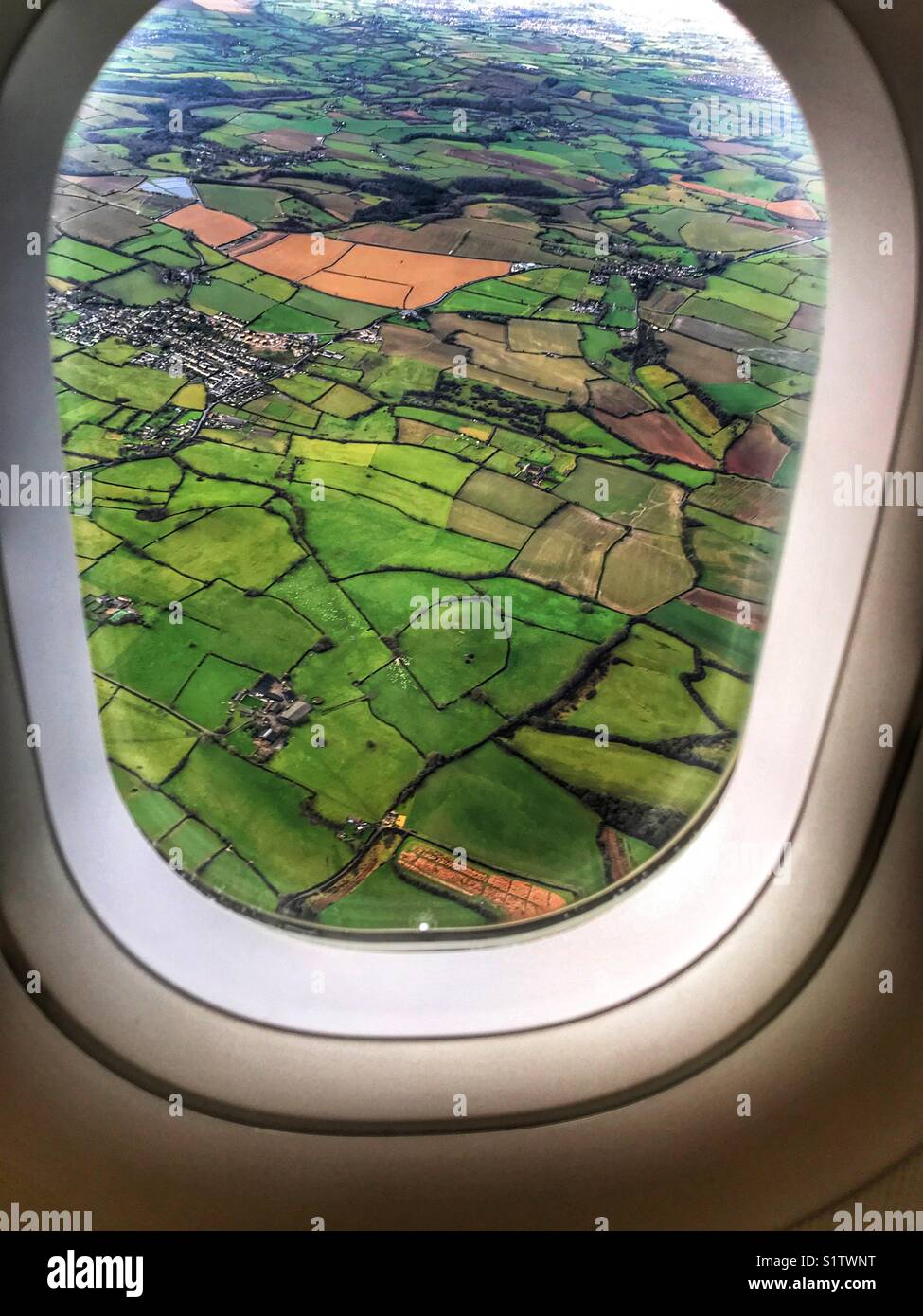 View from an aeroplane over green fields in winter, coming in to land at Bristol, UK. - Smartphone Captured Stock Image