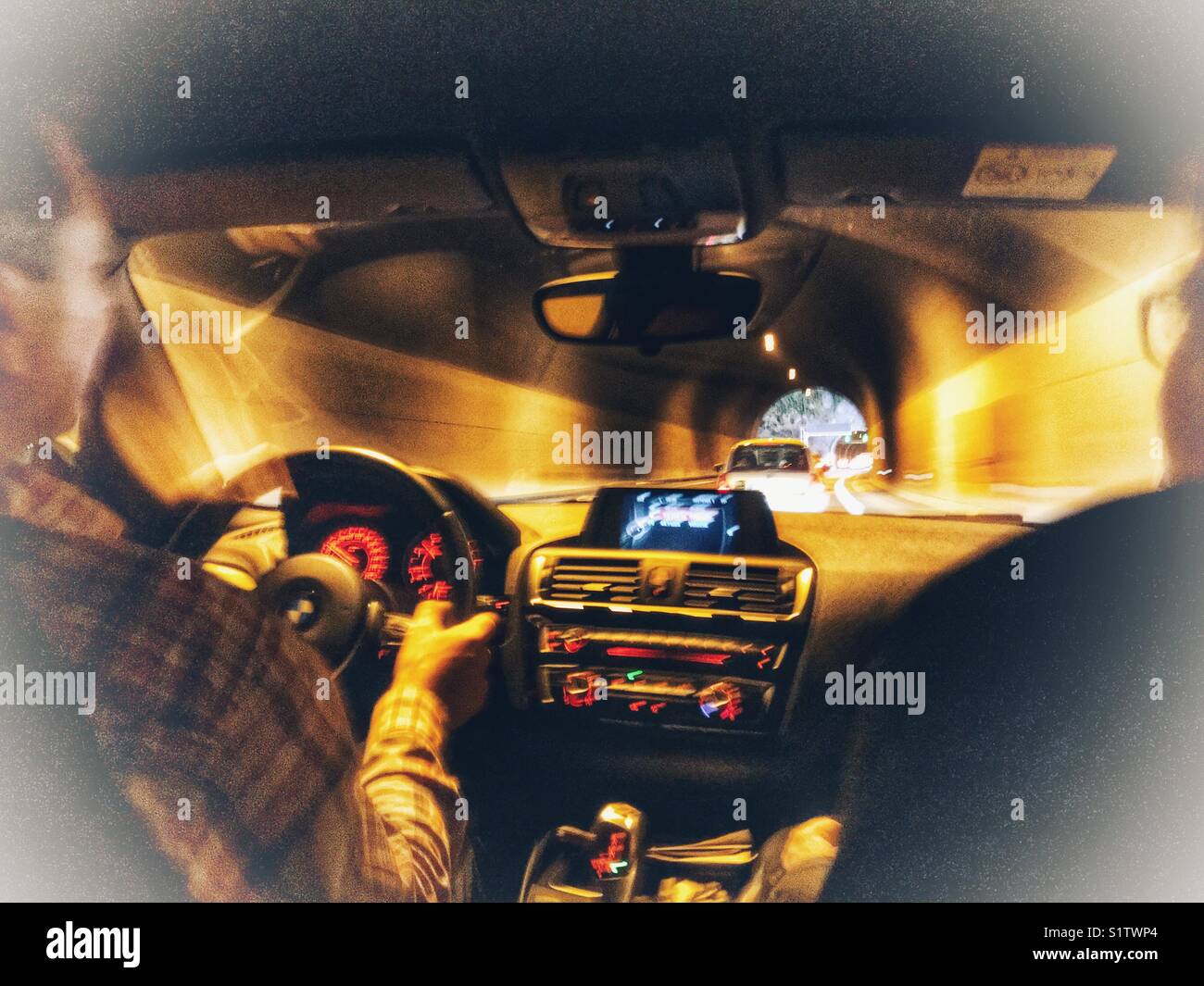 Two people in a car, driving through a tunnel at night - Smartphone Captured Stock Image