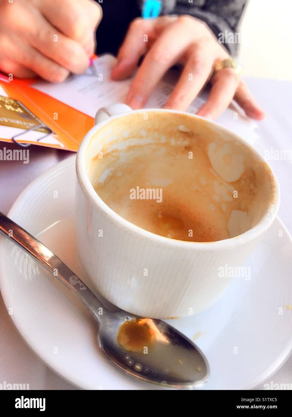 Man paying bill at table with empty cappuccino cup at restaurant in New York City - Smartphone Captured Stock Image