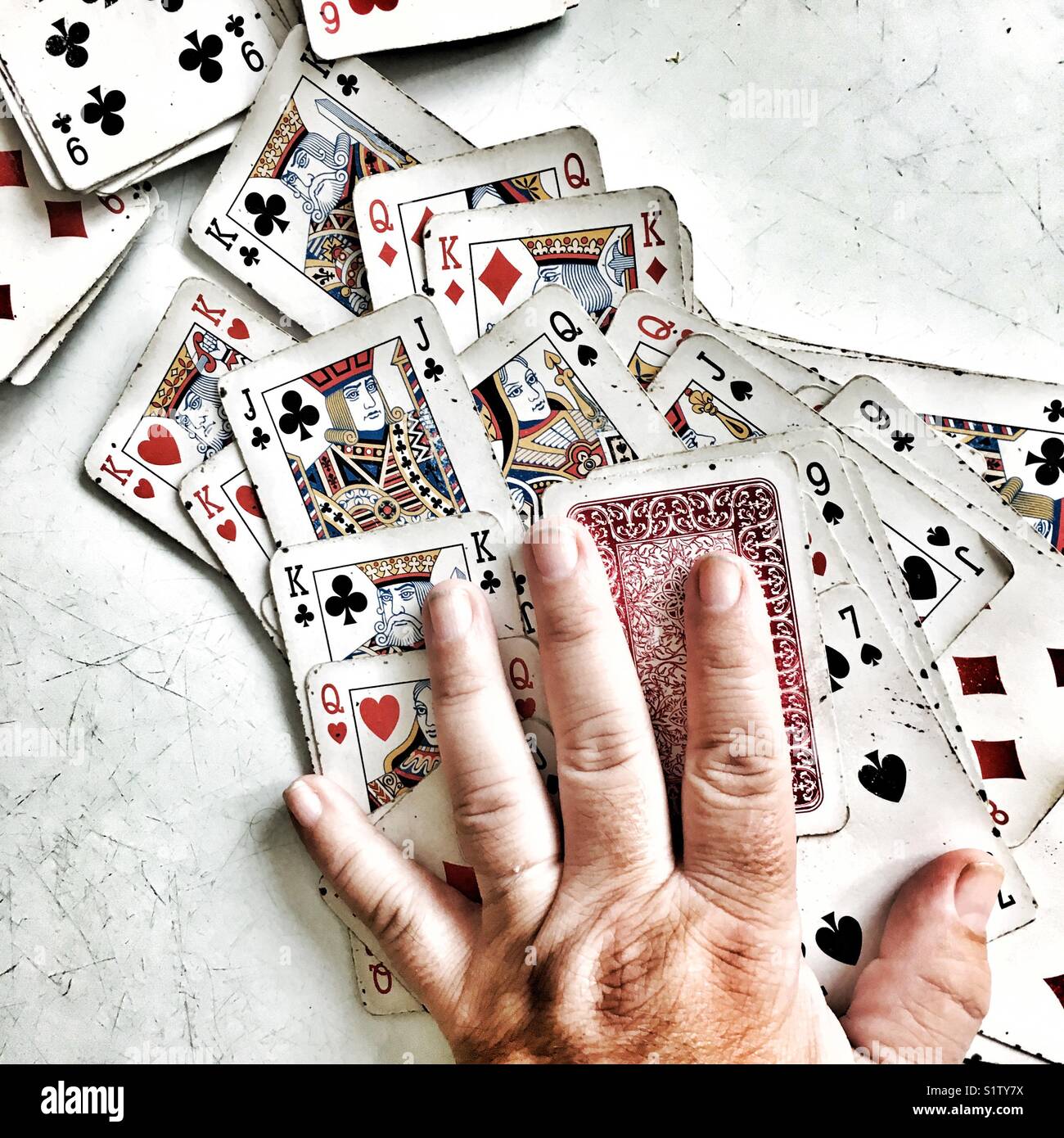 Used playing cards and hand on the table - Smartphone Captured Stock Image