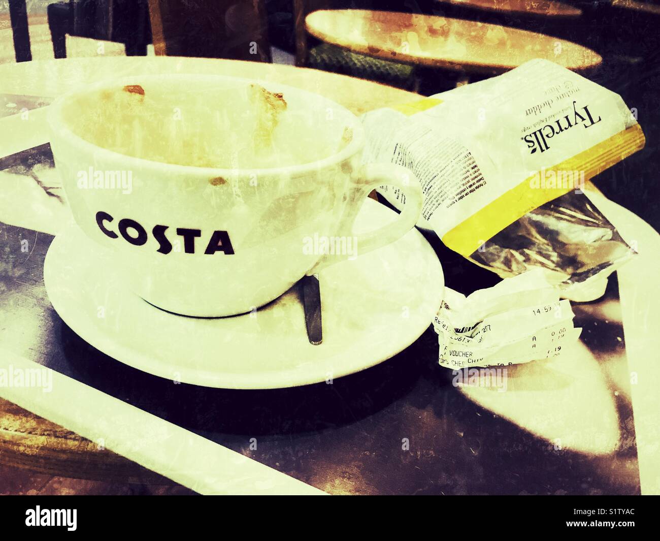 Empty costa coffee cup and packet of crisps - filter applied Stock Photo