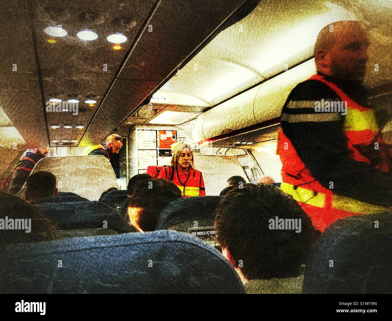 Emergency services. Medics boarding a plane which has made an emergency landing in Nantes, France, to attend a passenger who needs to be hospitalised. Stock Photo