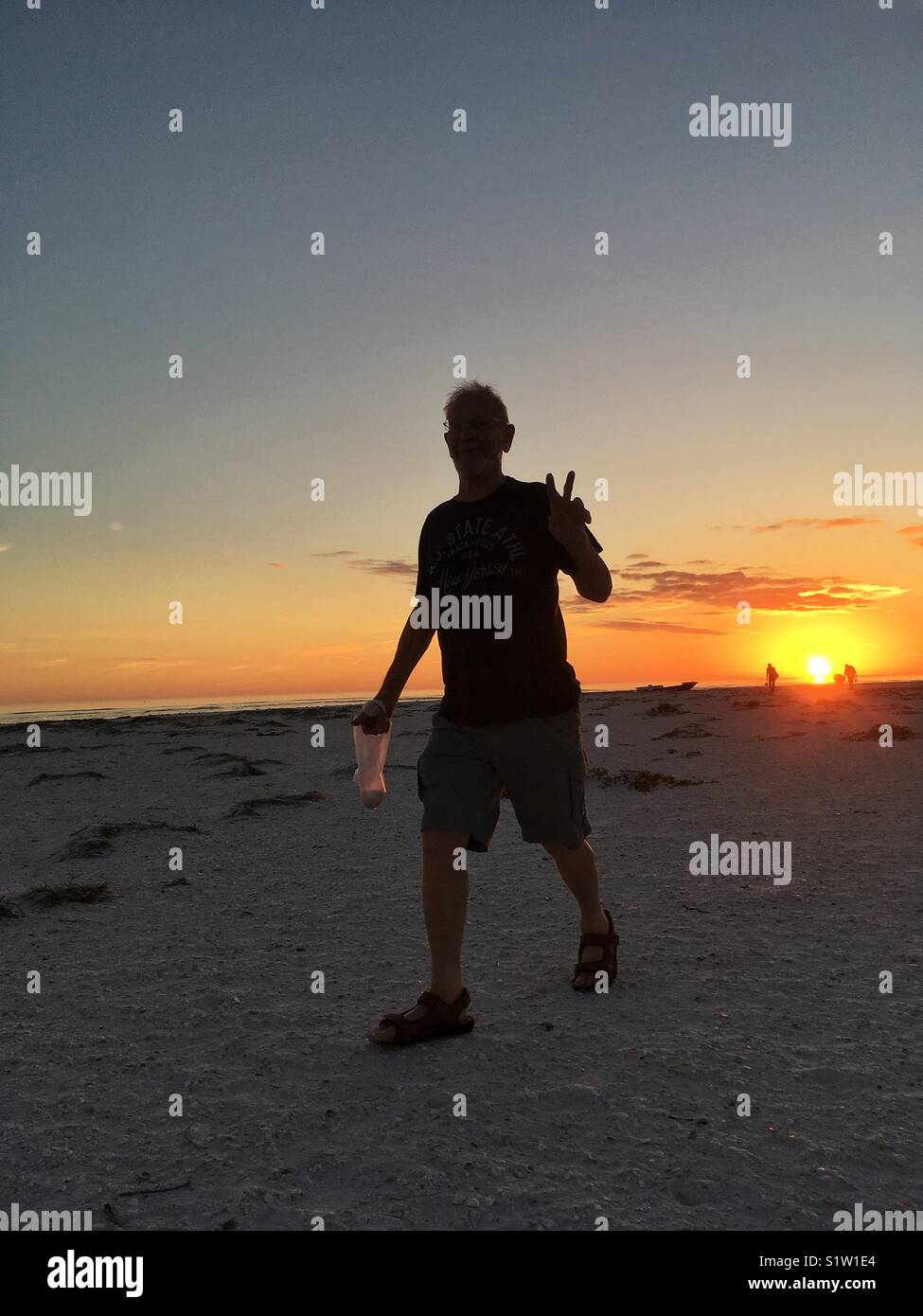 Man enjoying a stroll on Anclote Key at sunset in Florida - Smartphone Captured Stock Image