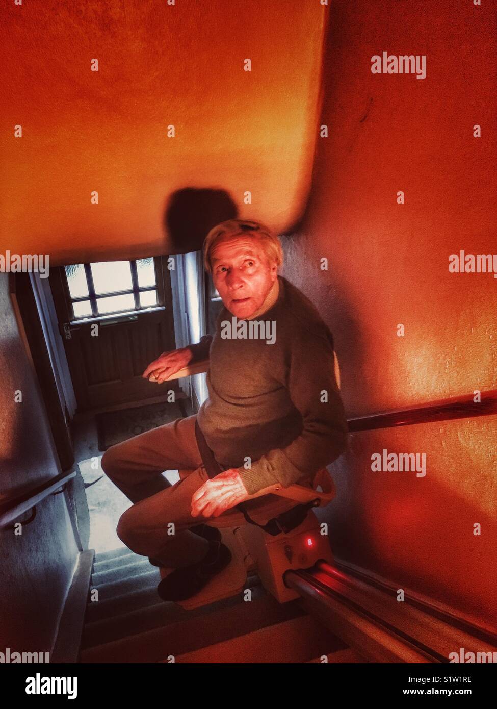 Elderly man using a stair lift - Smartphone Captured Stock Image