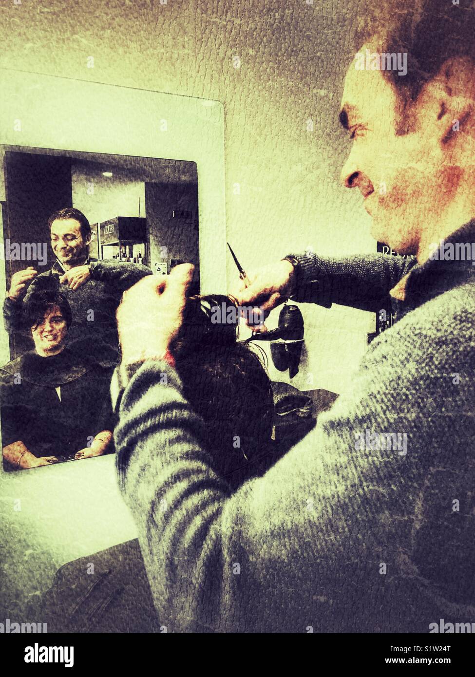 Male hairdresser cutting a young woman’s hair - Smartphone Captured Stock Image