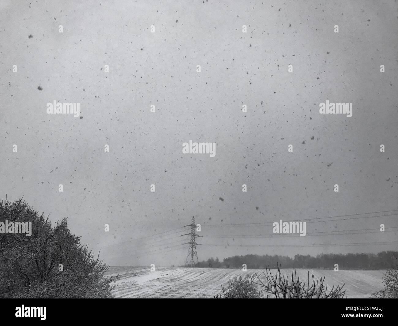 Snowy field with a pylon Stock Photo - Alamy