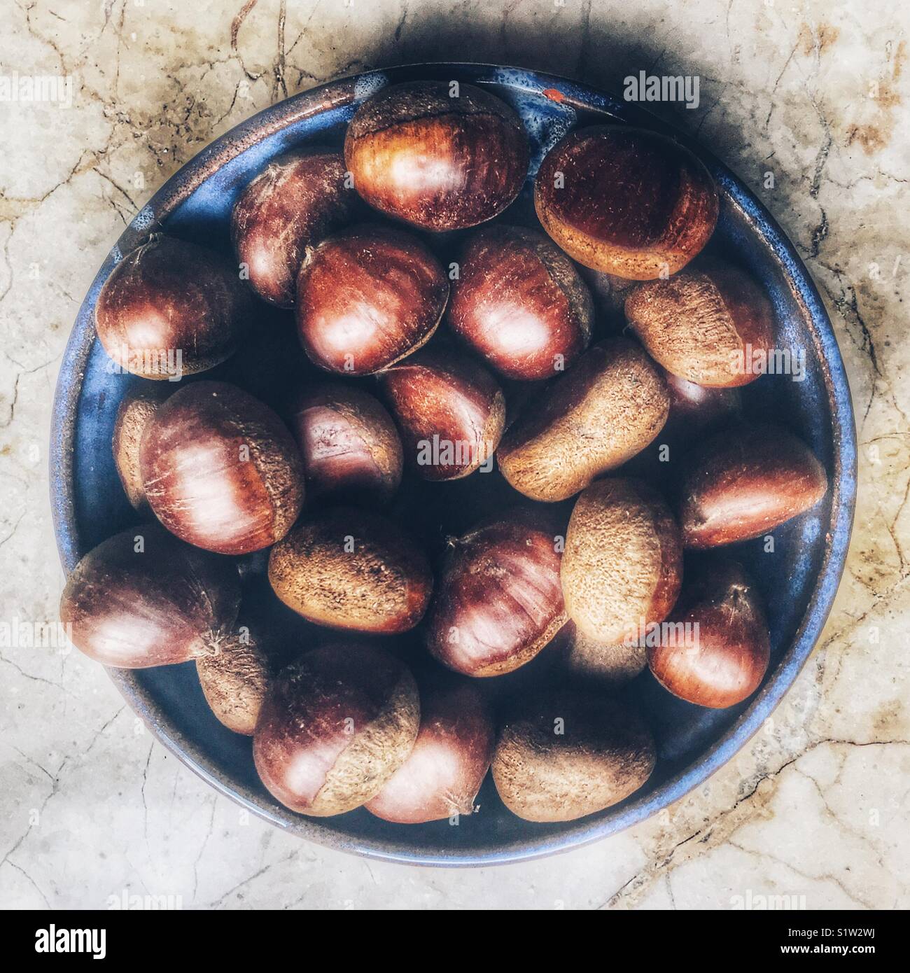 Chestnuts in a blue bowl, high angle view - Smartphone Captured Stock Image