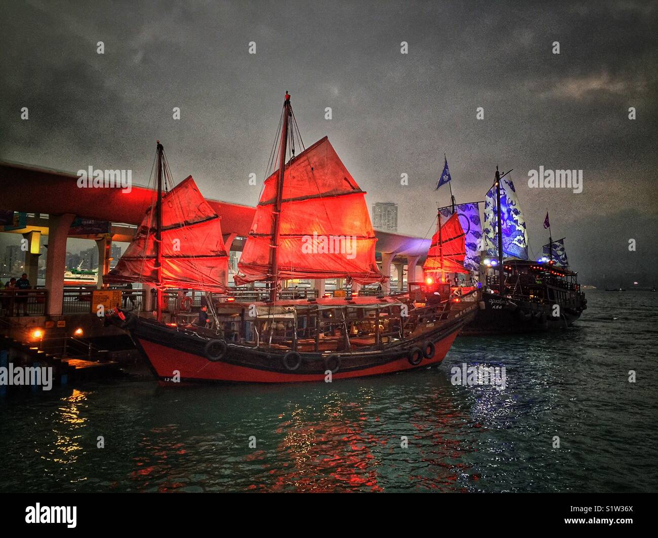 ‘Duk Ling’ and ‘Aqualuna II’, replica Chinese junks, transport tourists for sightseeing cruises on Victoria Harbour, Hong Kong - Smartphone Captured Stock Image