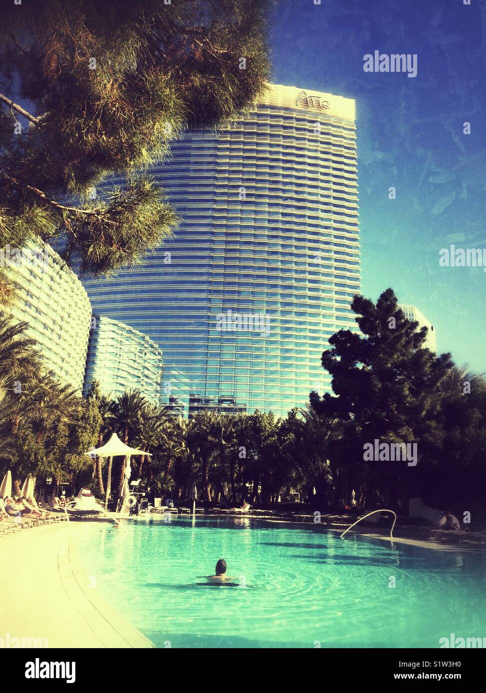 Man swimming in one of the oval heated pools at Aria Resort and Hotel in Las Vegas in December Stock Photo