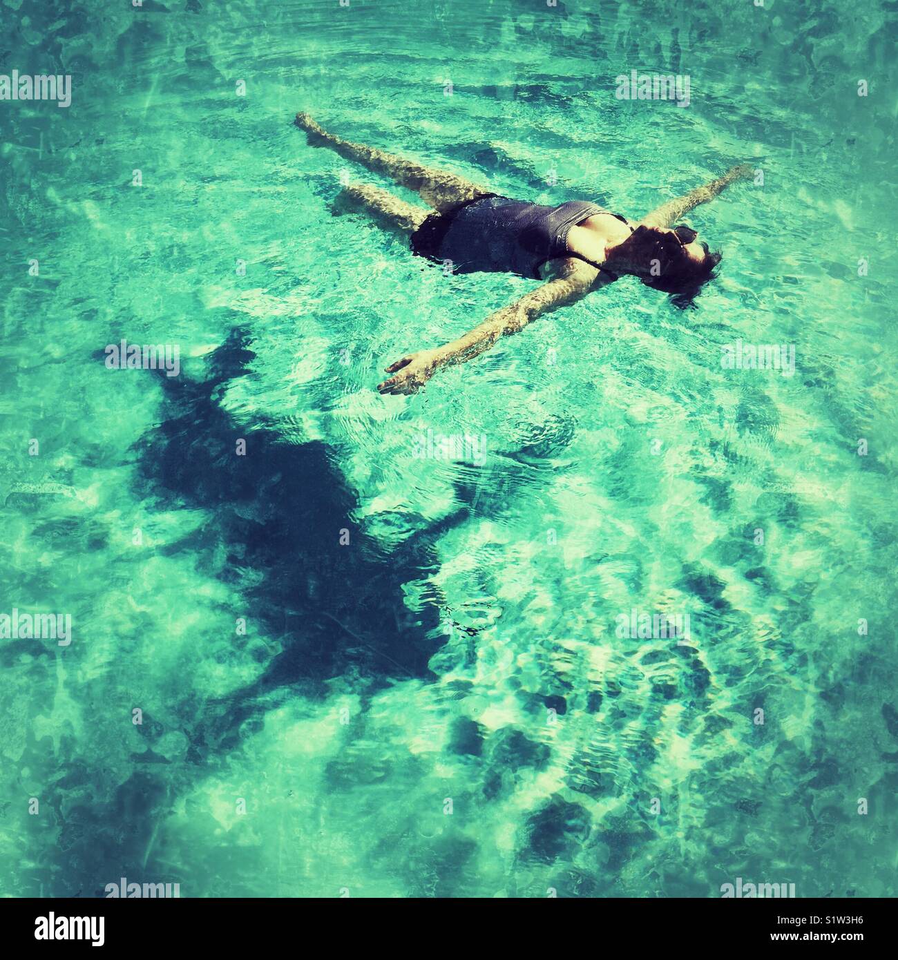 middle aged woman floating on her back in the pool - Smartphone Captured Stock Image