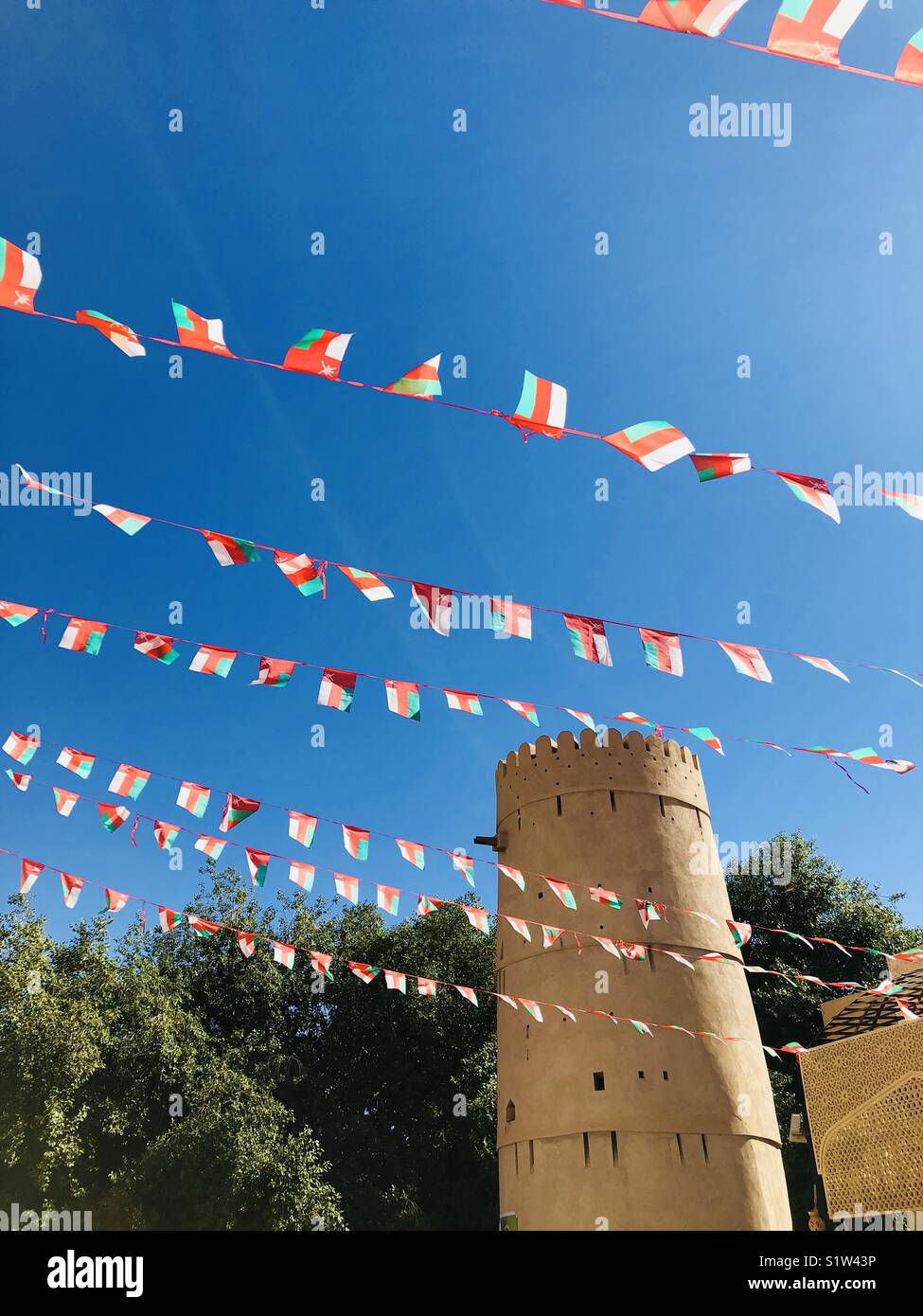 Oman flags in Nizwa and a fort Stock Photo - Alamy